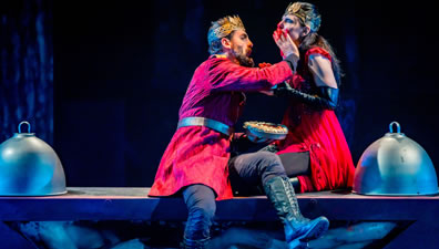 Photo of Saturninus and Tamora eating pie on a table